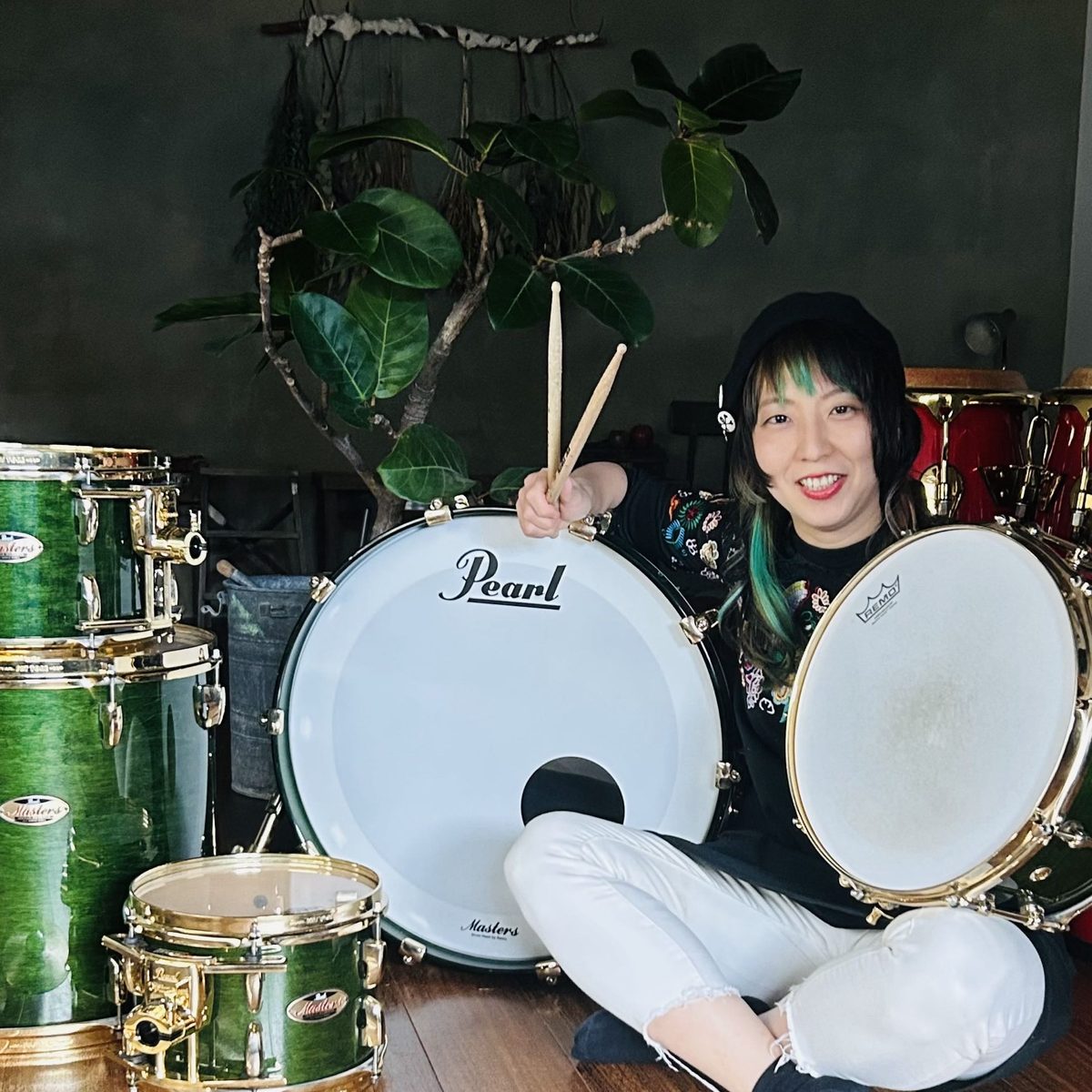 ドラムセットと一緒に写る近藤里保